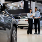 Two salespeople working together in a car showroom