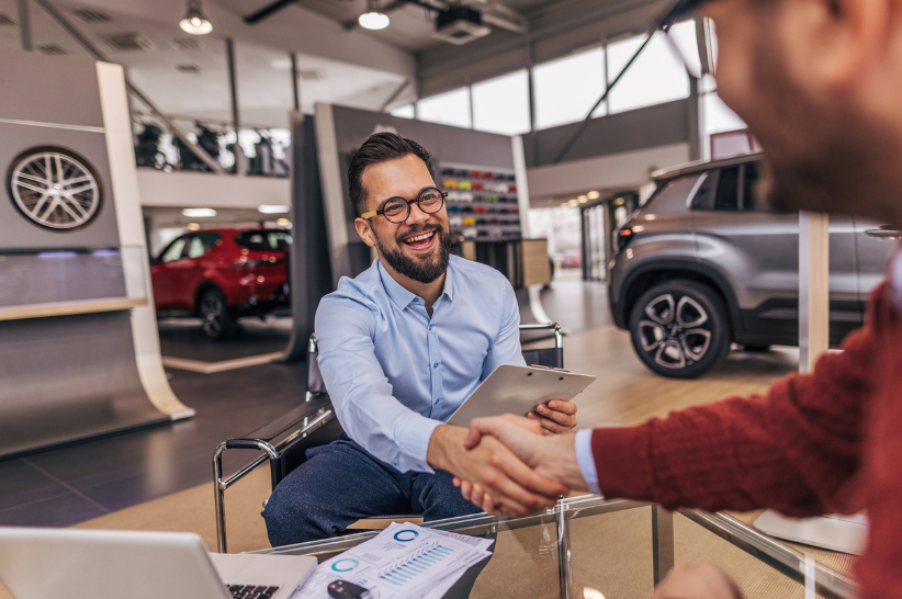 car dealer shaking hands with customer
