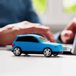 little car sitting next to laptop.