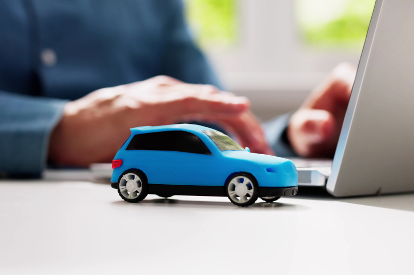 little car sitting next to laptop.