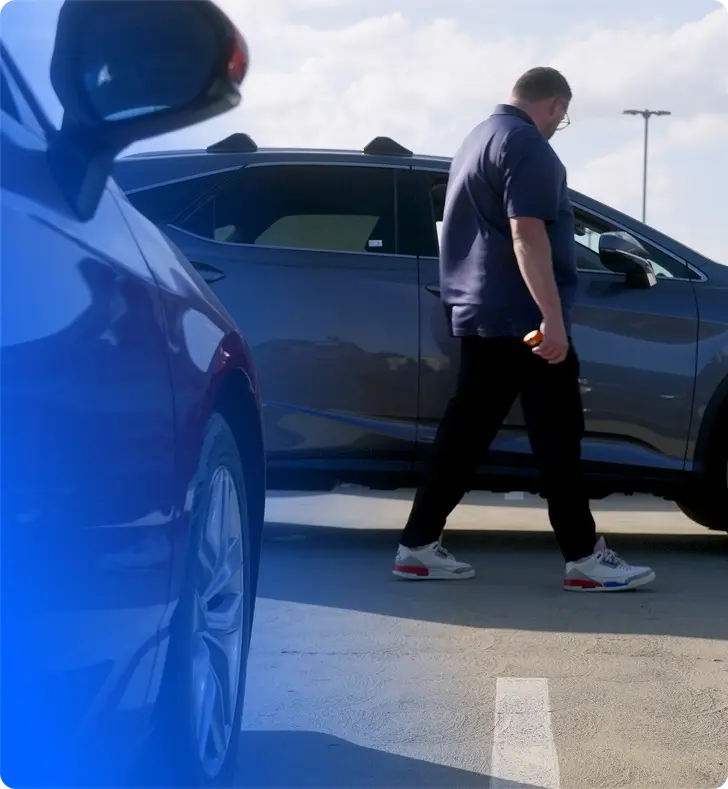 An OPENLANE Inspector walking next to a vehicle