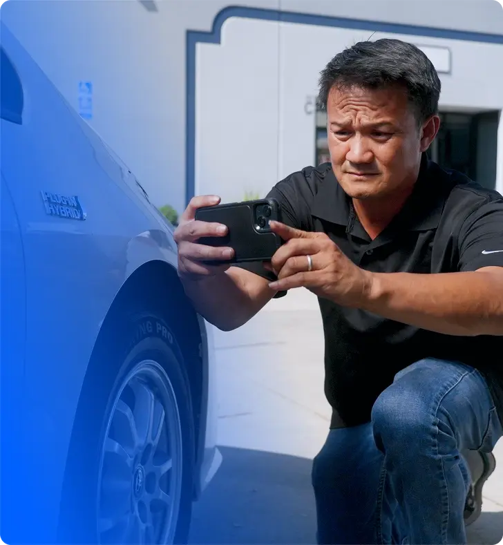 An OPENLANE Inspector taking a photo of a vehicle