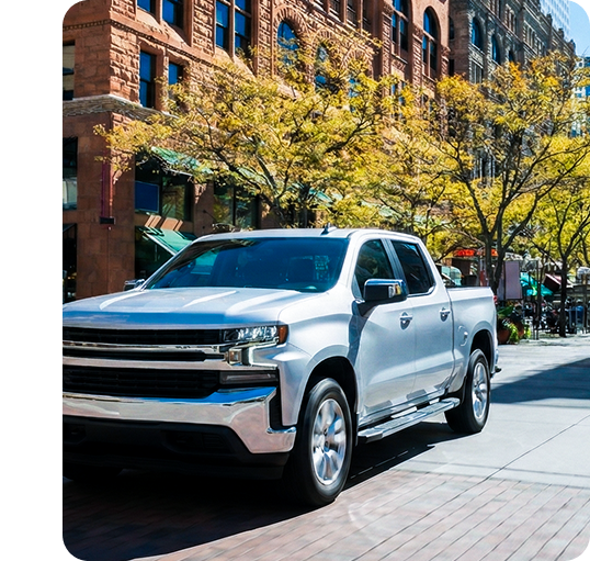 Silver Truck driving down a city street