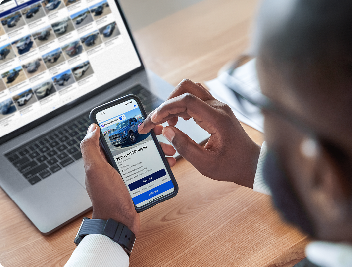 Man Using OPENLANE App in front of Laptop