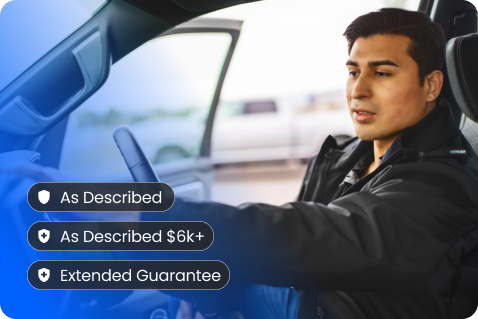 A man sits in the driver’s seat of a car with the door open. Overlay text lists features: “As Described,” “As Described $6k+,” and “Extended Guarantee.” The background is slightly blurred.